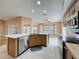 Beautiful kitchen island, stainless steel dishwasher, and cooktop offer a chef-friendly space at 18549 Grand Club Dr, Hudson, FL 34667