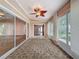 Bright sunroom featuring tile flooring, sliding glass doors and windows with roller shades at 18549 Grand Club Dr, Hudson, FL 34667