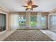 Bright sunroom featuring a leaf ceiling fan, tile flooring, comfortable wicker seating, and a glass coffee table at 18549 Grand Club Dr, Hudson, FL 34667