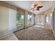 Bright sunroom featuring tile flooring, sliding glass doors and windows with roller shades, and a ceiling fan at 18549 Grand Club Dr, Hudson, FL 34667
