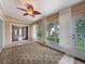 Relaxing sunroom with an ornate ceiling fan, large windows, and access to the outdoor patio at 18549 Grand Club Dr, Hudson, FL 34667