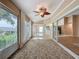 Bright sunroom features lots of windows, decorative ceiling fan, and access to the lanai and home's interior at 18549 Grand Club Dr, Hudson, FL 34667