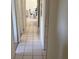 Hallway with tiled floors and white walls leads to the home's bedrooms at 2010 Warrington Way, Tampa, FL 33619