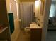 Compact bathroom featuring a vanity sink, toilet, and shower with a patterned curtain for privacy at 2239 Curtis S Dr, Clearwater, FL 33764