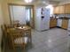Functional kitchen with ample cabinet space, a dining area, and a bright white refrigerator at 2239 Curtis S Dr, Clearwater, FL 33764