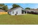 View of the home's exterior and yard, featuring a covered patio and lush green lawn at 243 Chardonnay Pl, Valrico, FL 33594
