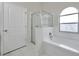 Bright bathroom featuring a tub, shower, and arched window at 243 Chardonnay Pl, Valrico, FL 33594