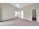 Spacious bedroom with ceiling fan, neutral carpeting, walk-in closet, and ample natural light at 243 Chardonnay Pl, Valrico, FL 33594