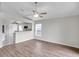 Open-concept living room featuring wood floors, fan, and a view into the modern white kitchen at 243 Chardonnay Pl, Valrico, FL 33594