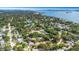 Expansive aerial view of a neighborhood near the water, with houses nestled among mature trees at 245 Grove Cir N, Dunedin, FL 34698