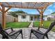 Backyard patio with pergola and chairs, perfect for outdoor relaxation and entertaining in a private setting at 245 Grove Cir N, Dunedin, FL 34698