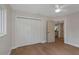 Bright bedroom featuring wood floors, a window, closet doors, ceiling fan, and an interior door at 245 Grove Cir N, Dunedin, FL 34698