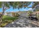 Charming single-story home with a well-maintained lawn, a driveway, and a golf cart at 245 Grove Cir N, Dunedin, FL 34698