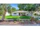 Charming single-story home featuring manicured landscaping and a covered front porch at 245 Grove Cir N, Dunedin, FL 34698