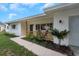 Charming front porch with wooden railing, stylish lighting, and comfortable seating, enhancing curb appeal at 245 Grove Cir N, Dunedin, FL 34698