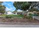 Charming one-story home featuring lush landscaping and a well-maintained front yard, enhancing its curb appeal at 245 Grove Cir N, Dunedin, FL 34698
