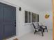 Inviting porch with seating, stylish decor, and a view of the bright, modern exterior at 245 Grove Cir N, Dunedin, FL 34698