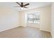 Bright bedroom featuring a large window, ceiling fan, and neutral flooring at 302 Lake Parsons Grn # 104, Brandon, FL 33511
