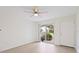 Sunlit living room featuring sleek flooring, a ceiling fan, and sliding glass doors for easy access to outdoor space at 302 Lake Parsons Grn # 104, Brandon, FL 33511
