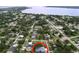 Aerial view showcasing a blue two-story home nestled in a neighborhood with lush surroundings near the lake at 309 Congress St, Oldsmar, FL 34677