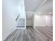 View of finished basement with black stairs, gray wood floors, and white walls at 309 Congress St, Oldsmar, FL 34677