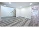 View of finished basement with black stairs, gray wood floors, and white walls and recessed lighting at 309 Congress St, Oldsmar, FL 34677