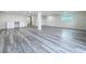 Large finished basement featuring gray wood floors, recessed lighting, and white columns at 309 Congress St, Oldsmar, FL 34677