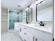 Bathroom featuring double sinks with quartz countertop, black fixtures, and glass-enclosed shower at 309 Congress St, Oldsmar, FL 34677