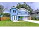 Charming two-story blue home with a second story balcony and a well-manicured front lawn at 309 Congress St, Oldsmar, FL 34677
