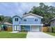 Charming two-story blue home featuring a second story balcony, white trim and an attached garage at 309 Congress St, Oldsmar, FL 34677
