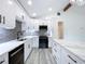 A bright kitchen featuring white cabinets, stainless steel appliances, and a large center island at 309 Congress St, Oldsmar, FL 34677