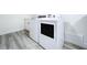 Laundry room featuring modern appliances and gray wood-look flooring, showcasing a functional space at 309 Congress St, Oldsmar, FL 34677