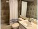Bathroom with shower, white curtain, beige tile, white vanity and light colored sink at 3151 Landmark Dr # 115, Clearwater, FL 33761