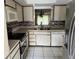 Traditional kitchen with tile floors, stainless steel refrigerator and white appliances and cabinets at 3151 Landmark Dr # 115, Clearwater, FL 33761