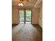 Living room with carpet, white walls, sliding glass door to patio and ceiling fan at 3151 Landmark Dr # 115, Clearwater, FL 33761