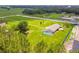 Aerial view of a property with a screened-in pool surrounded by a large green lawn at 34215 Kiefer Rd, Dade City, FL 33525