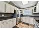 Well-lit kitchen featuring white cabinetry, stainless steel appliances, and dark countertops at 34215 Kiefer Rd, Dade City, FL 33525