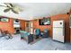 Screened lanai featuring seating area, fireplace, ceiling fan, TV, and refrigerator at 34215 Kiefer Rd, Dade City, FL 33525