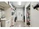 Well-lit laundry room with modern washer and dryer, storage shelves, sink, and gray wood-look flooring at 34215 Kiefer Rd, Dade City, FL 33525