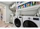 Laundry room with modern washer and dryer, utility sink, shelving, and wood-look flooring at 34215 Kiefer Rd, Dade City, FL 33525