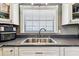 Stainless steel sink beneath a window with white cabinets and countertop appliances at 34215 Kiefer Rd, Dade City, FL 33525