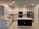 Bright kitchen features white cabinetry, stainless steel appliances, and a center island with dark base at 36233 Joseph Blake St, Zephyrhills, FL 33541