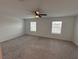 Large main bedroom offers plush carpet, two windows with blinds, and a ceiling fan at 36233 Joseph Blake St, Zephyrhills, FL 33541