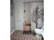 Compact bathroom featuring a shower with decorative curtain, vintage pink tub, and storage cabinet at 4300 E Bay Dr # 309, Clearwater, FL 33764