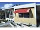 Charming home featuring a small porch, awning, and a well-kept garden area with small plants at 4300 E Bay Dr # 309, Clearwater, FL 33764