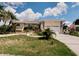 Inviting one-story home with lush landscaping, a two-car garage, and mature palm trees at 4434 Dewey Dr, New Port Richey, FL 34652