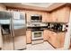 Traditional kitchen boasts stainless steel appliances, wood cabinets, and a tile backsplash, perfect for culinary enthusiasts at 4434 Dewey Dr, New Port Richey, FL 34652
