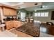 Open kitchen boasts wood cabinets, dark granite countertops, and a spacious island that seamlessly connects to the living area at 4434 Dewey Dr, New Port Richey, FL 34652