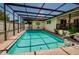 Refreshing pool with clear, blue water, enclosed within a screened cage and brick trim at 4434 Dewey Dr, New Port Richey, FL 34652