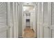 Hallway with two closets and a view into the all-white bathroom with hardwood floors and modern lighting at 4510 Overlook Ne Dr # 224, St Petersburg, FL 33703